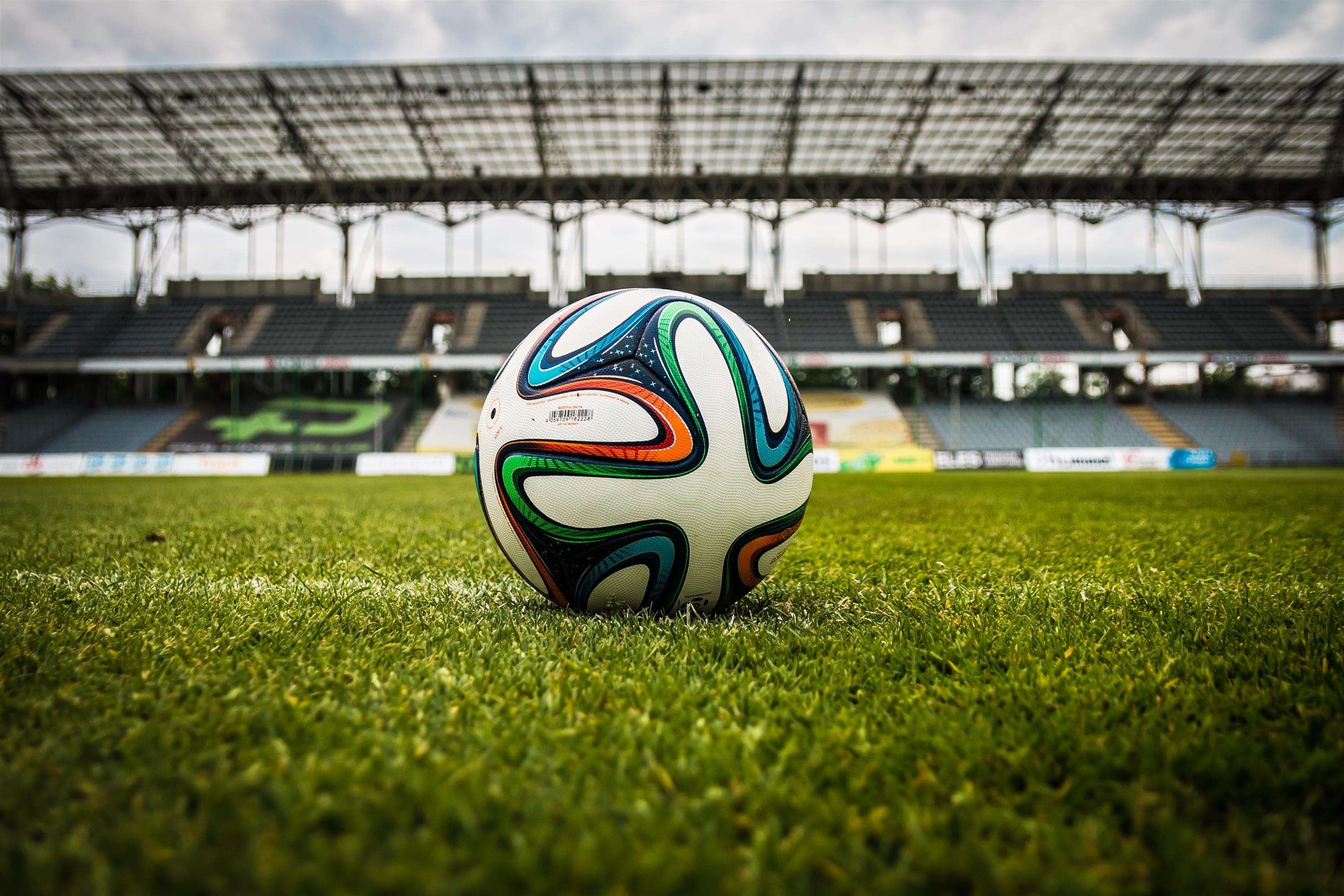 Ein Fußball liegt auf dem Rasen in einem Stadion