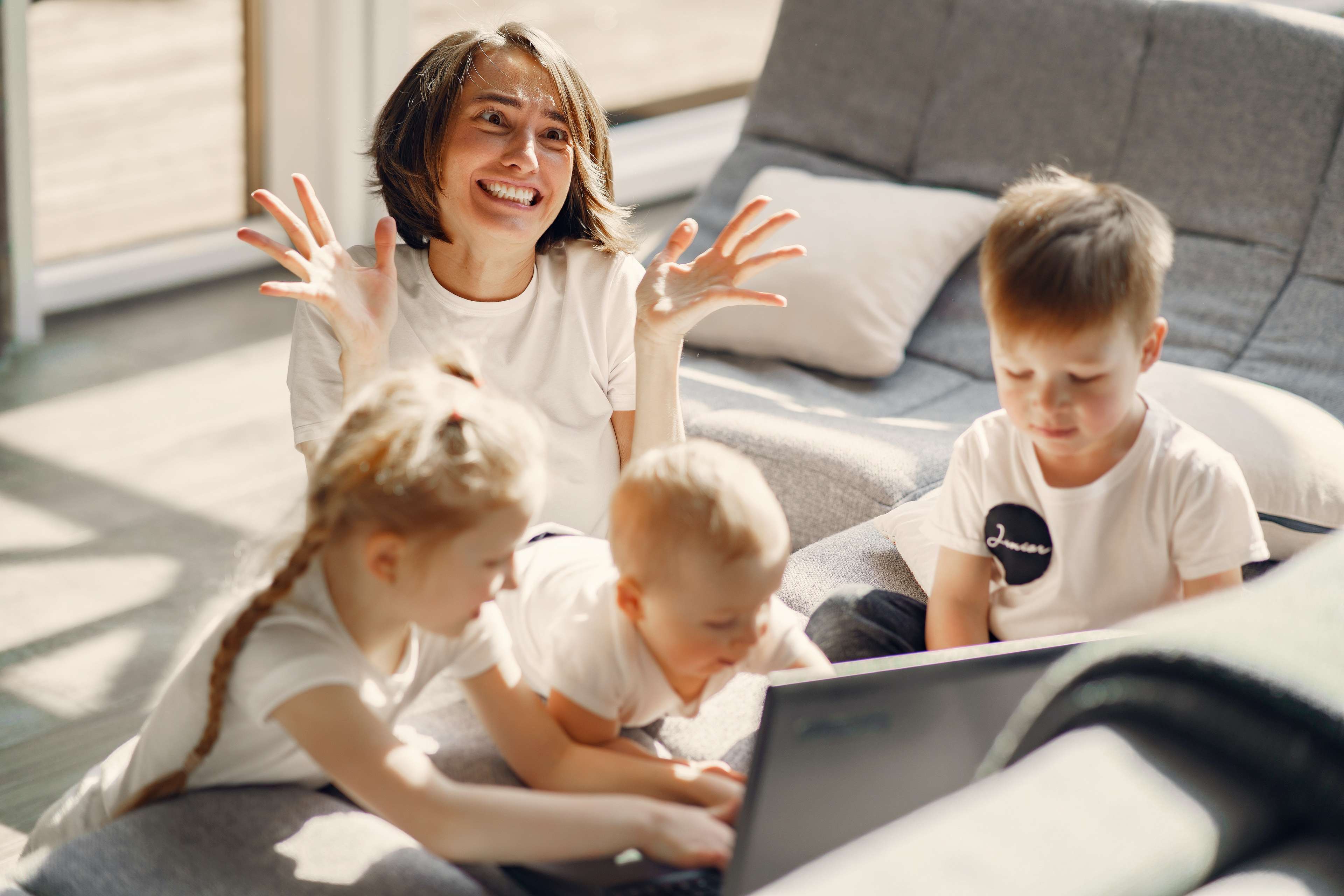 Frau mit Kindern ärgert sich über ihren Laptop